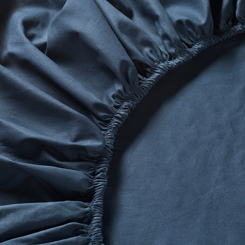 Sábana azul oscuro con sutil detalle elástico fruncido alrededor del bajo.