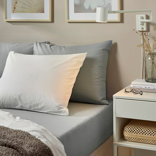 Acogedora cama con sábanas de algodón DVALA grises, almohadas suaves, mesita de noche y arte de pared. La sábana se adapta a colchones de hasta 26 cm.