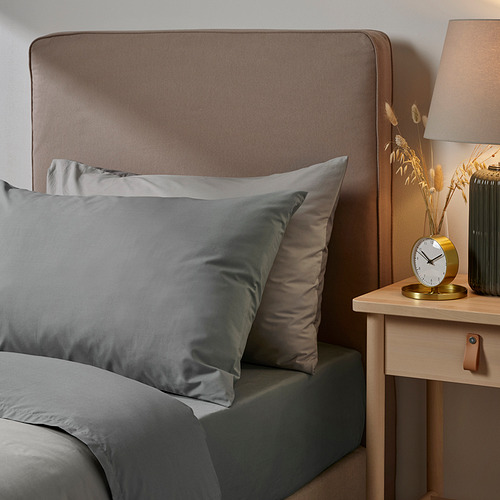 Funda de almohada gris Ullvida en mezcla de algodón/lyocell por cama, forma rectangular, suave y duradera. Más grande que el reloj y la lámpara en mesita de noche de madera.