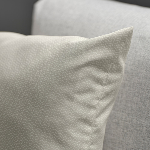 Primer plano de un acogedor cojín de color beige claro con un patrón sutil y un brillo suave, diseñado para la comodidad y el estilo.