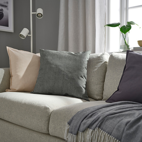 Sala de estar con sofá gris claro, cojines antracita y plantas verdes. O sofá gris, cojines y plantas en la sala de estar minimalista moderna.