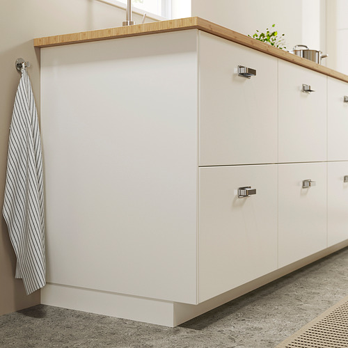 Armarios de cocina blancos con tiradores plateados y paño de cocina a rayas.