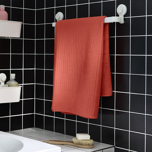 Toalla VÅGSJÖN naranja sobre perchero de pared de baño negro.