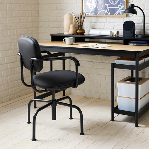 Moderna silla de oficina MULLSJÖ negra con diseño ergonómico debajo de un escritorio sencillo.