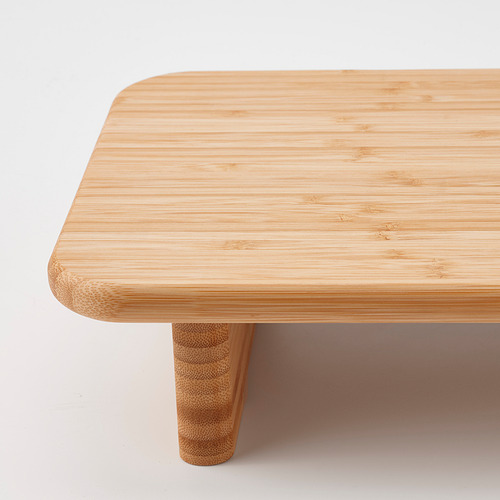 Mesa de centro minimalista de bambú con bordes lisos y redondeados y patas robustas.