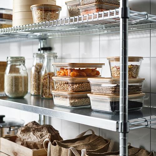 Despensa bien organizada con recipientes de vidrio que contienen granos, frijoles y frutas secas en los estantes. Tapas transparentes y de bambú para facilitar la visualización y la frescura.