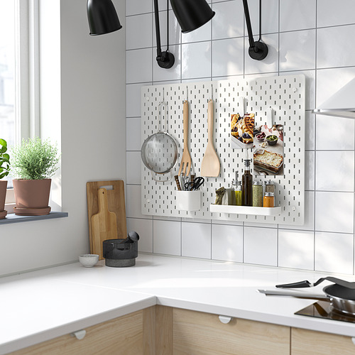 Cocina moderna con tablero perforado SKÅDIS, utensilios y plantas.