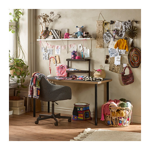 Acogedor escritorio de manualidades con hilo, proyectos y decoración; Escritorio LAGKAPTEN negro y silla gris.