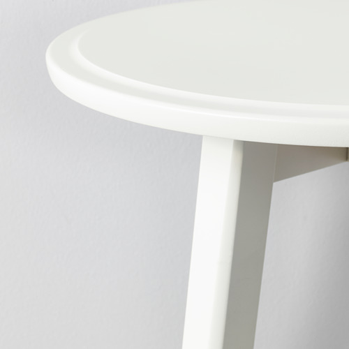 Un elegante tablero redondo blanco con bordes lisos, sostenido por patas robustas.