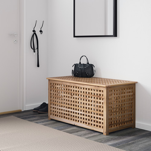 Cofre de rejilla de madera con bolsa, en habitación blanca.