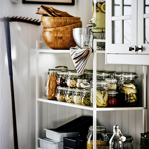 Frascos de vidrio cuidadosamente organizados en estantes, ideales para conservar alimentos, encurtidos y mermeladas, con cuerpos transparentes para mayor visibilidad.