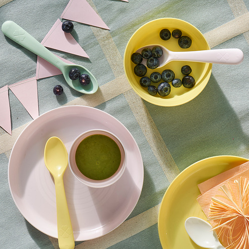Coloridos platos y cucharas para niños con arándanos y batido.