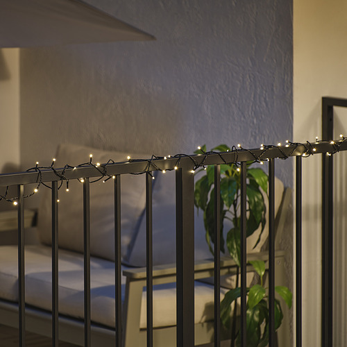 Barandilla iluminada con luces decorativas, creando un ambiente al aire libre. Las luces LED son visibles a lo largo de la barandilla de metal, lo que mejora la estética nocturna.