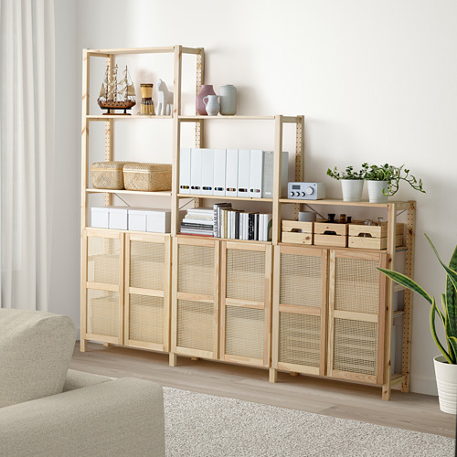 Unidad de almacenamiento IVAR con puertas de bambú y pino, decorada con jarrones, libros y plantas en la sala de estar.
