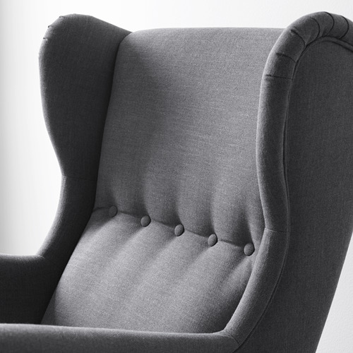Elegante sillón orejero en primer plano, con tela de alta calidad. Costuras detalladas y construcción robusta.