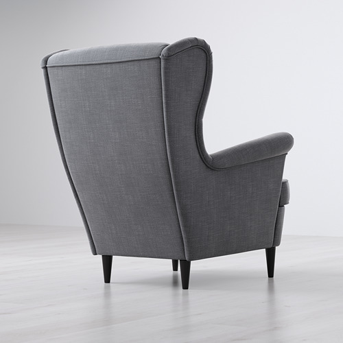 Sillón de tela gris con respaldo alto y apoyo y patas de madera.