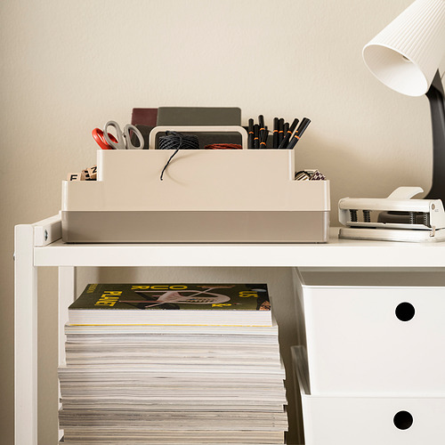 Organizador de escritorio KUGGIS, de dos capas con asa superior, almacena objetos pequeños y solapas. Blanco, plástico. Encaja bien en superficies junto a una lámpara y libros.