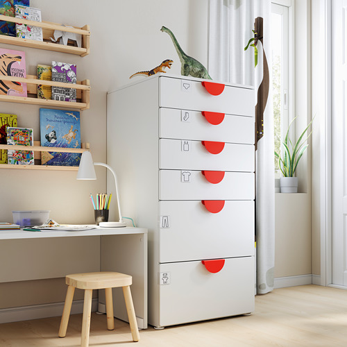 Habitación infantil con cofre SMÅSTAD, juguetes de dinosaurios, libros, escritorio, lámpara, planta.