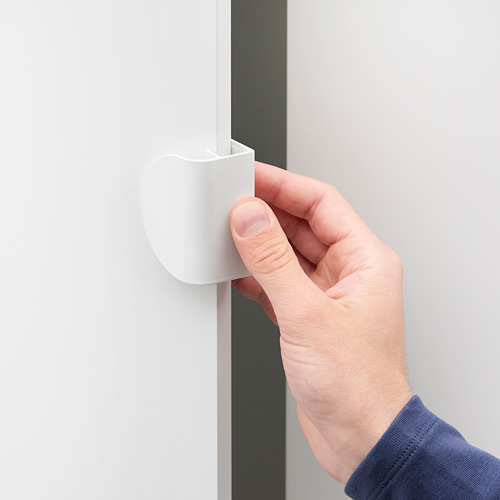 Una mano presionando una manija blanca y redondeada de LATMASK en una puerta, mostrando una fácil instalación mediante clip.