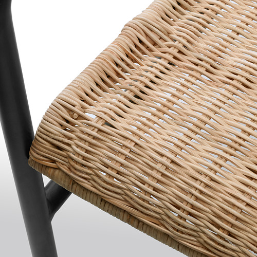 Primer plano de una silla de mimbre tejido, que muestra una textura intrincada y un material de ratán natural.