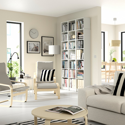 Sala de estar moderna con muebles ligeros, estantería BILLY, sofá y sillas blancas, mesa de café, grandes ventanales.