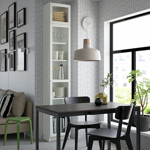 Sala de estar moderna con juego de comedor negro, taburete verde, estantería BILLY, vista a la ciudad.