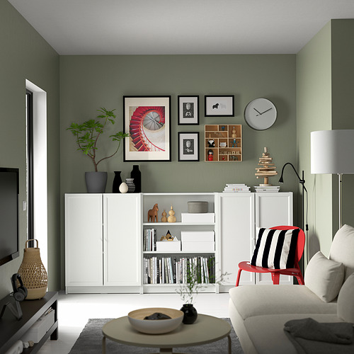 Sala de estar moderna con paredes verdes, estantería BILLY blanca, decoración en blanco y negro, silla roja, sofá gris y mesa de centro de madera.