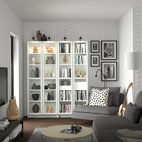 Papel pintado geométrico, librería BILLY, sofá gris con almohada, mesa de centro, guitarra.