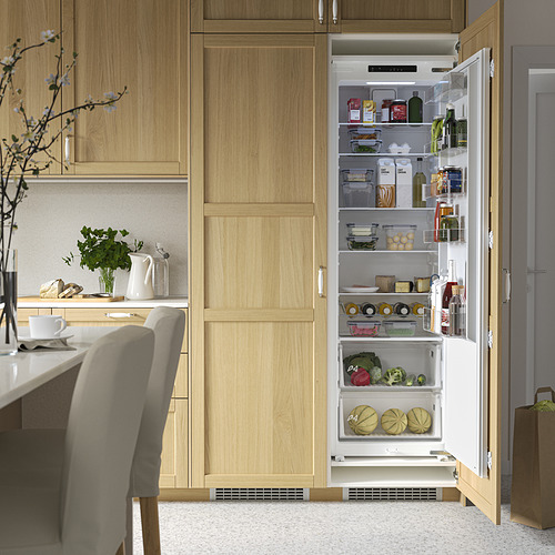 Cocina moderna con nevera abierta integrada que muestra varios alimentos, estantes ajustables de vidrio templado, iluminación led y panel de control táctil.