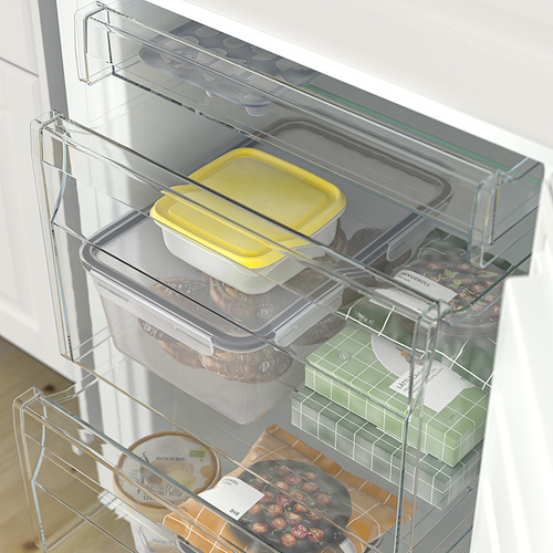 Cajón de la nevera con recipientes transparentes y comida organizada. Estantes ajustables y botellero para almacenamiento personalizable.