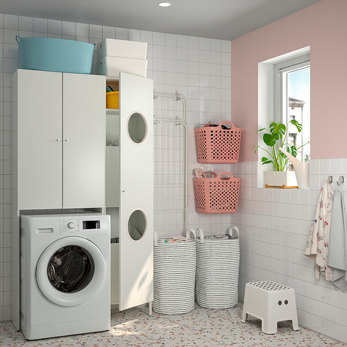Un lavadero con paredes de azulejos blancos, una lavadora de carga frontal y almacenamiento superior en blanco con una cesta azul en la parte superior.