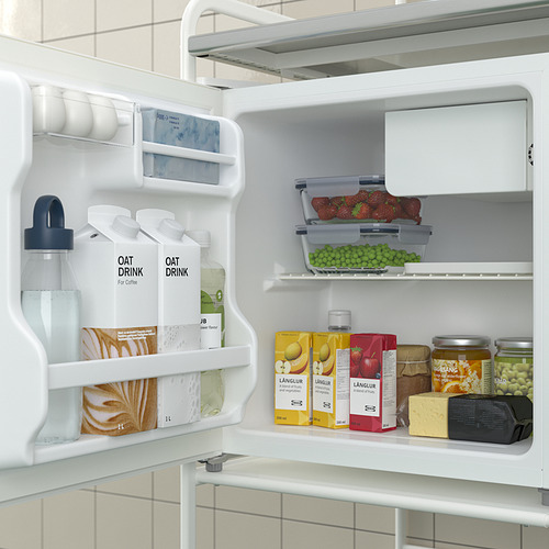 Refrigerador abierto con bebidas de avena, fruta, jugo y recipientes de almacenamiento. Compartimentos de estanterías y puertas visibles.