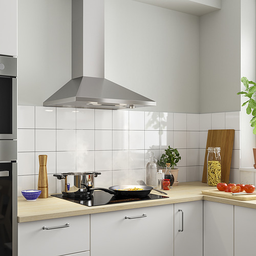 Cocina moderna con campana extractora de acero inoxidable. Gabinetes blancos, encimeras de madera, utensilios de cocina.