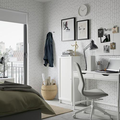 Dormitorio moderno, una estantería blanca BILLY con estantes ajustables, silla de madera y computadora portátil en un escritorio. Papel pintado geométrico y una acogedora alfombra están presentes.