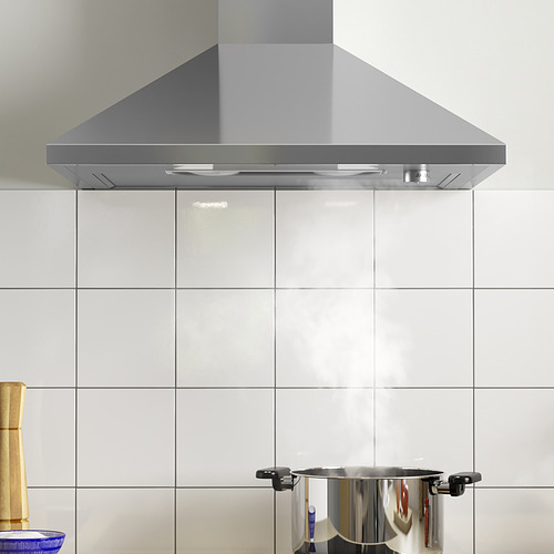 Campana extractora de acero inoxidable con luz led montada sobre el salpicadero de la cocina con azulejos blancos.