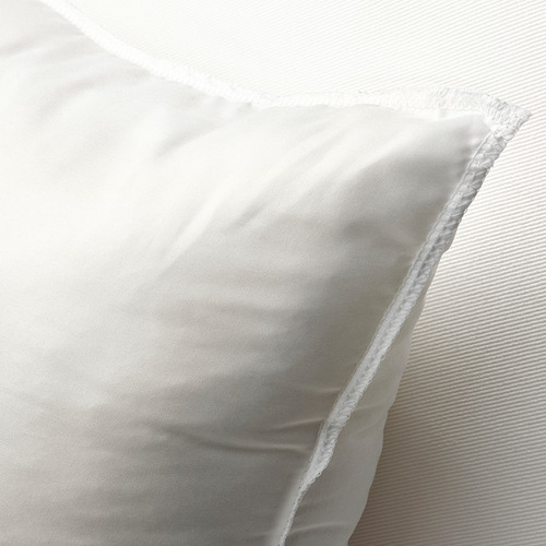 Un primer plano de un cojín blanco de felpa, que muestra su tela suave y texturizada y su diseño regordete y acogedor.