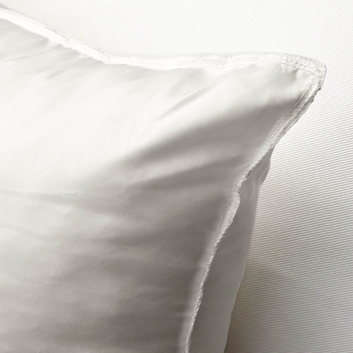 Almohadilla de cojín blanca y afelpada con tela suave y de tejido apretado, acolchada para soporte y comodidad, acostada sobre una superficie texturizada.