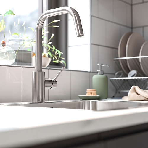 Moderno grifo ÄLMAREN con dispensador de jabón verde y planta.