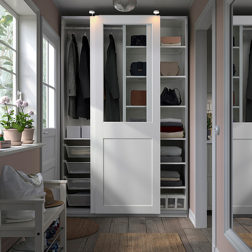 Armario abierto PAX con ropa, puertas de cristal, organización ordenada en una habitación acogedora.