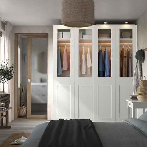Dormitorio moderno con gran armario blanco PAX con ropa colorida y cama gris.