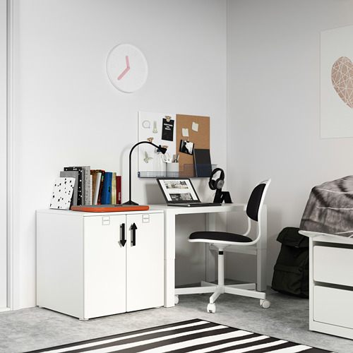 Moderna oficina en casa con armario, silla y escritorio SMÅSTAD blancos, con ordenador portátil, libros y reloj.