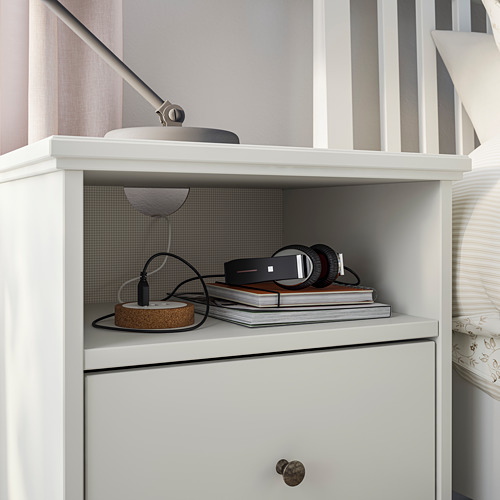 Mesita de noche IDANÄS blanca con estantes, auriculares, libros, lámpara.