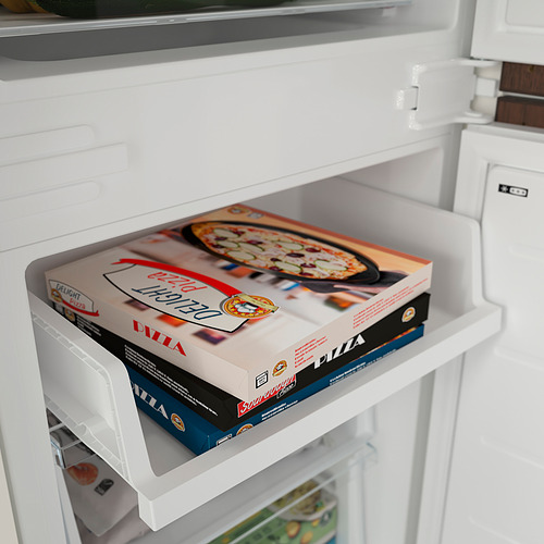 El cajón del congelador abierto revela cajas de pizza deliciosas, mostrando la función de congelación rápida.