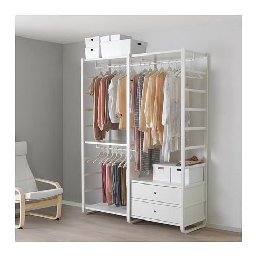 Almacenaje ELVARLI de ikea blanco con estantes, cajones y barras para colgar junto a una pared gris y una silla blanca.