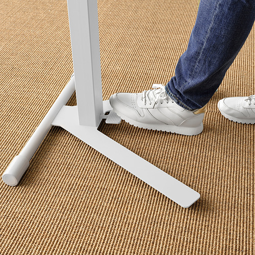 Persona que usa el soporte para computadora portátil MITTZON; Se ajusta con el pie, diseño robusto sobre alfombra tejida.