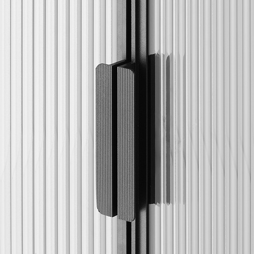 Primer plano en blanco y negro de la elegante y moderna puerta del armario con vidrio texturizado y manija minimalista.