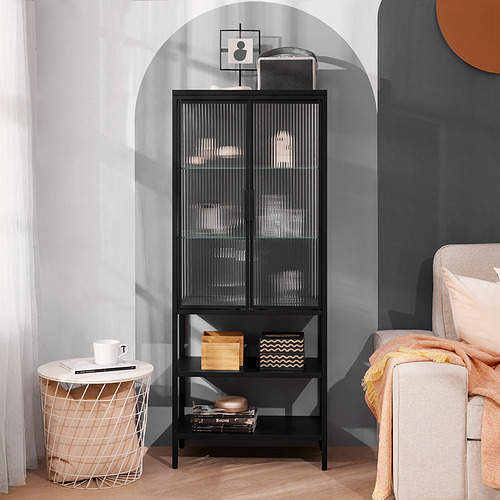 Mueble MOSSJÖN negro con puertas de cristal texturizado y estantes abiertos, que contienen decoración, junto a una pequeña mesa y silla.