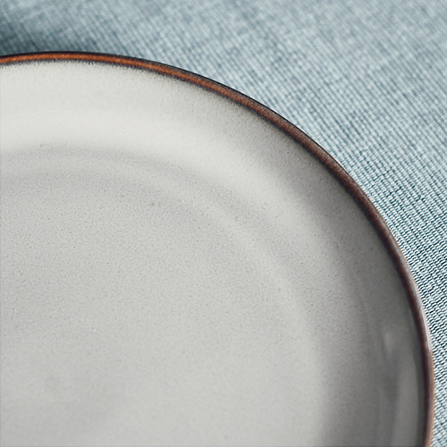 Elegante placa lateral texturizada con borde rústico sobre denim azul.
