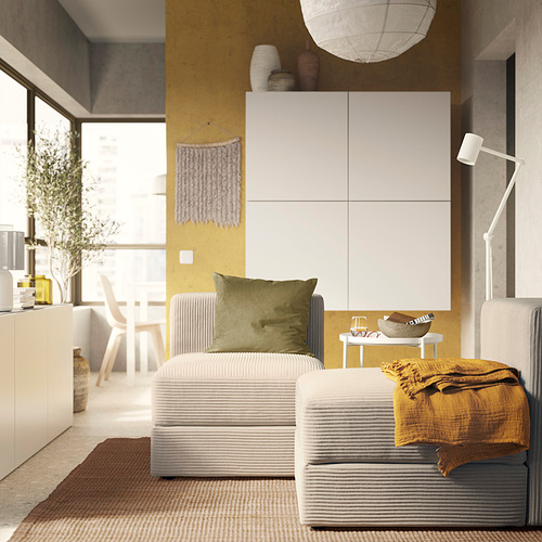 Sala de estar moderna con un sofá JÄTTEBO gris a rayas, almohada oliva, manta amarilla, lámpara colgante blanca y un diseño acogedor y contemporáneo.