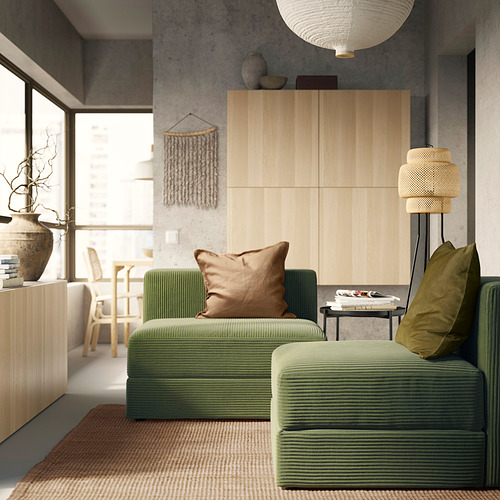 Sala de estar moderna con sofá JÄTTEBO verde, mueble de madera y lámpara tejida.